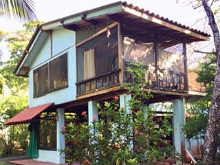 The front of the house that faces the beach with the upstairs side deck